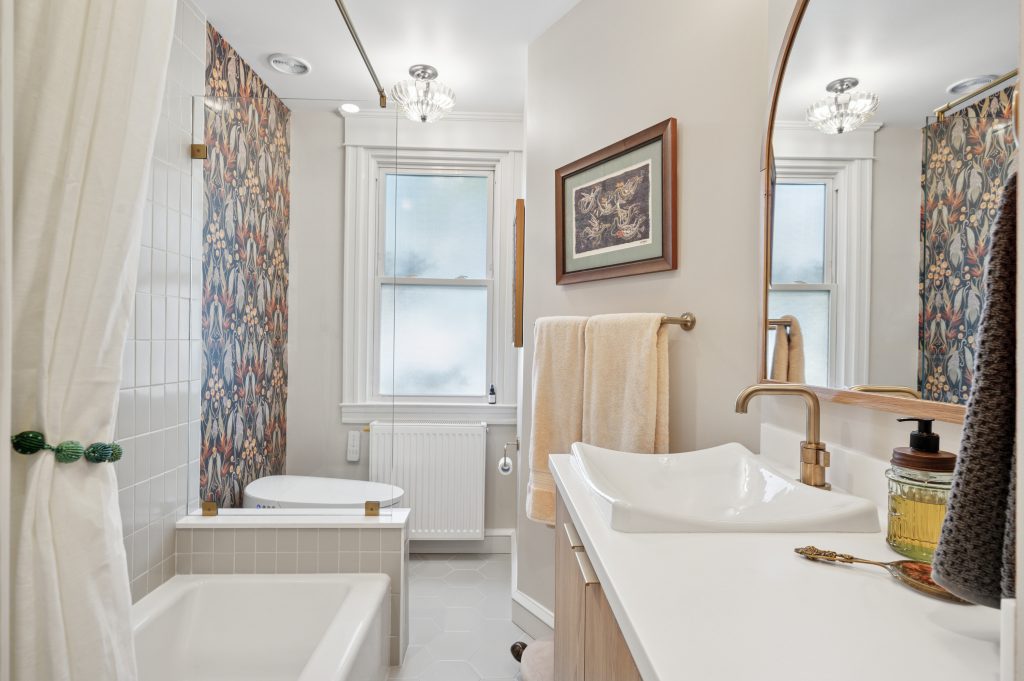 Bathroom with both tile and wallpaper.