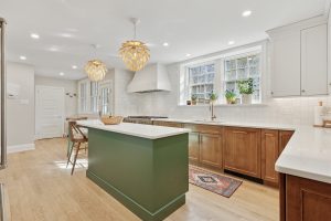 Modern kitchen with green island and artichoke pendant lights.